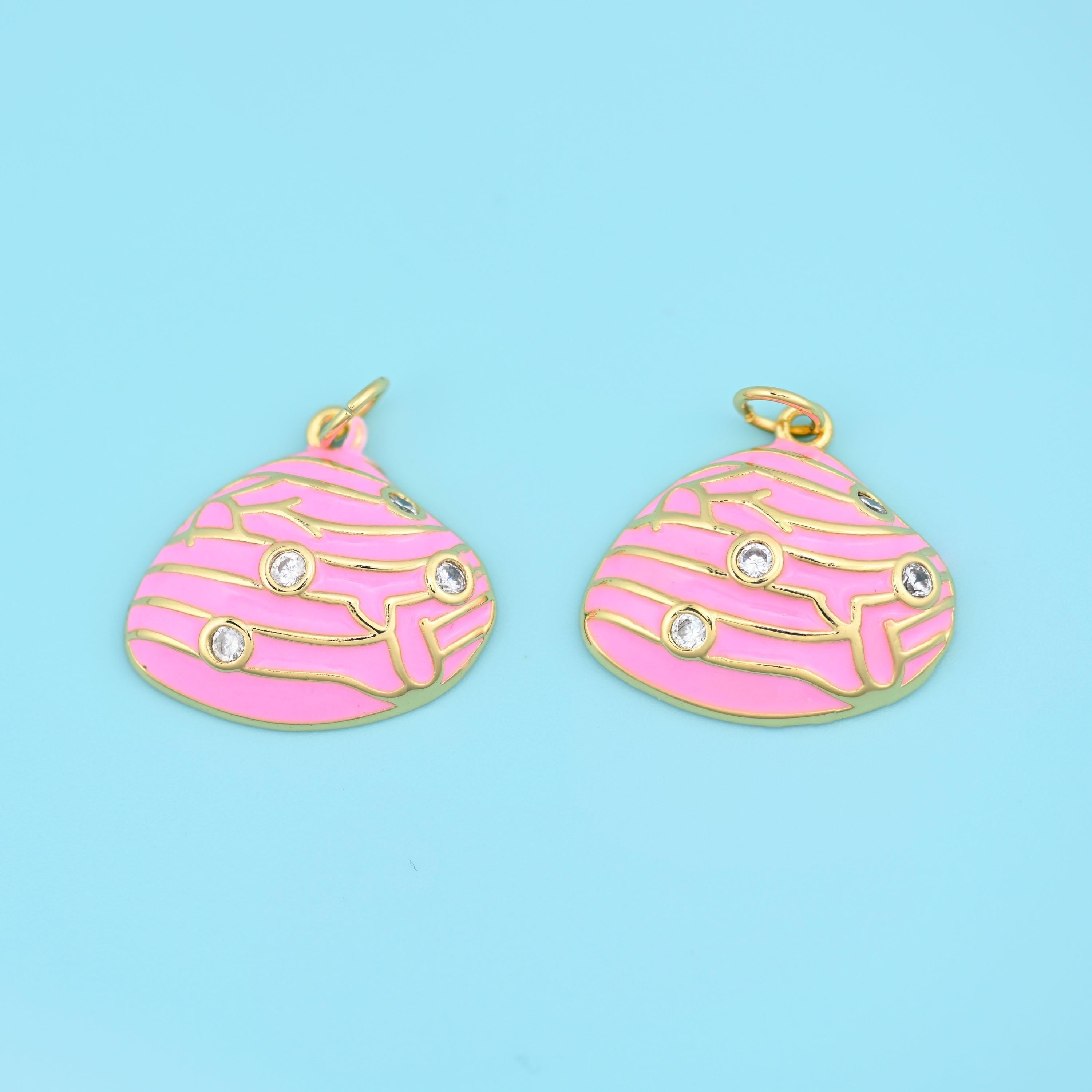 A scalloped clam shell in smooth enamel, its ridges drawn in fine raised gold and set with three tiny clear zircon stones…