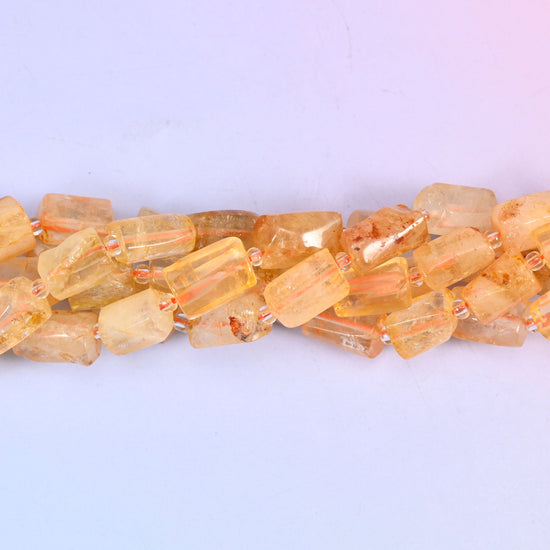 Faceted tubes with real heft to them, cut so the flat planes pass light around the stone rather than off a single curve — a substantial cylinder that still reads as refined on the wire.