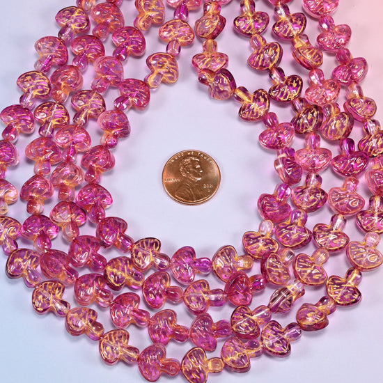 Pink gold flat mushroom glass beads coiled flat into several concentric rings around an open center.