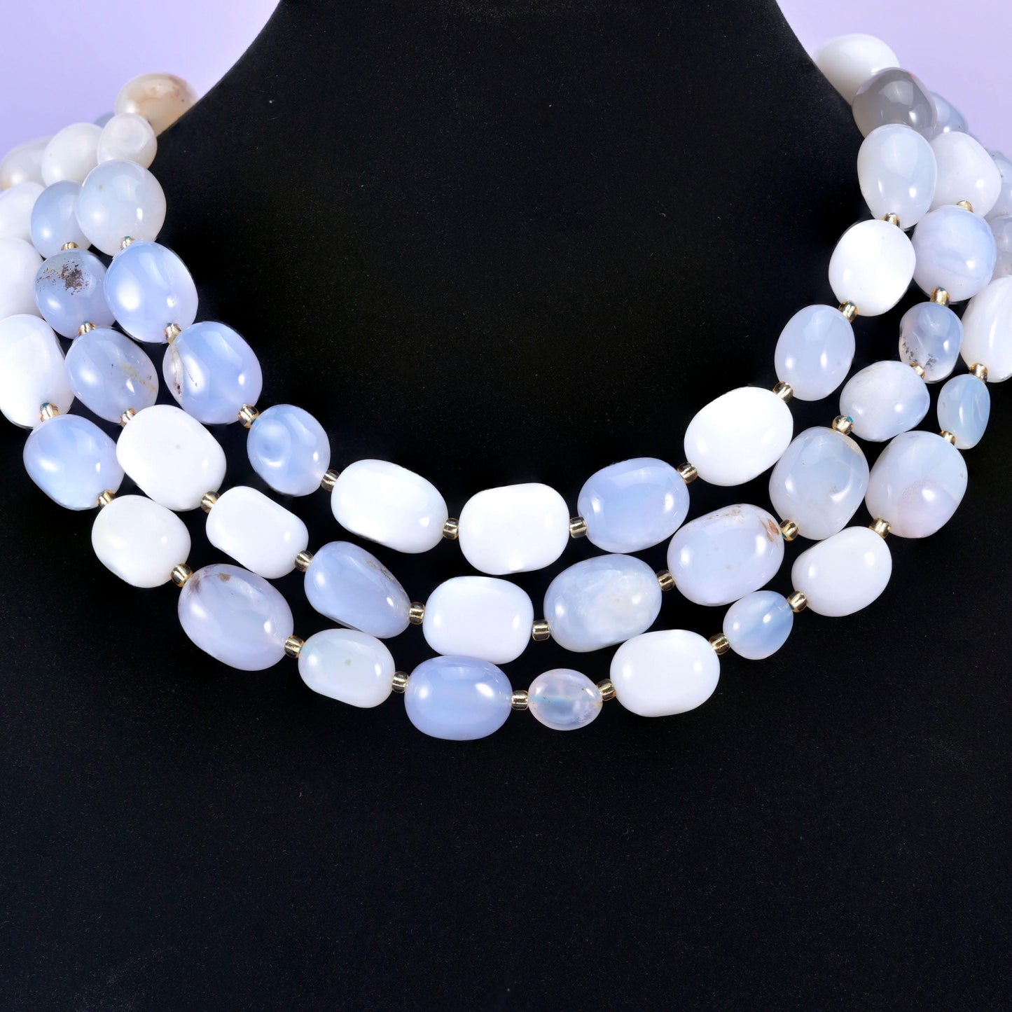 Chunky chalcedony nugget strands worn as a layered collar on a black display neck form