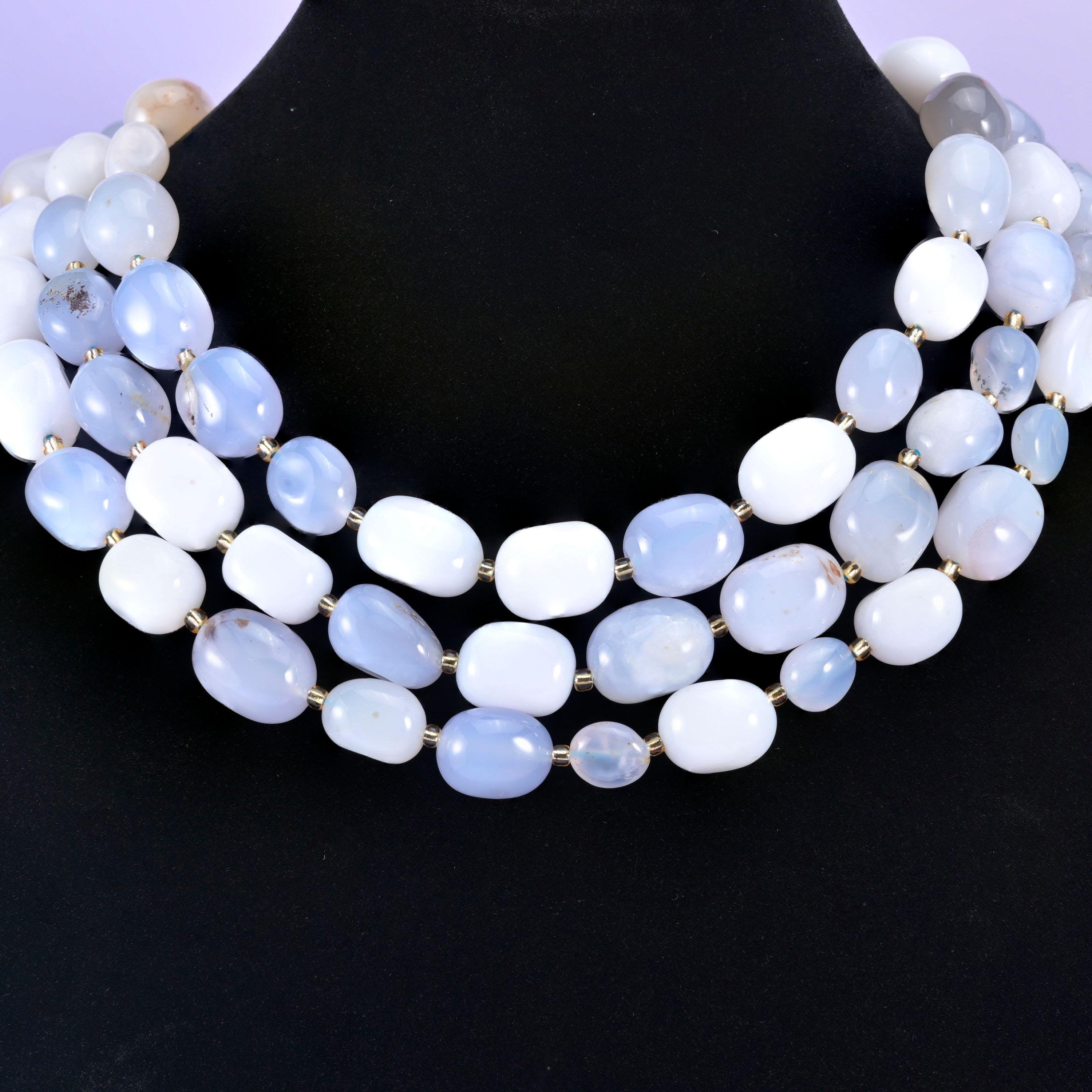Chunky chalcedony nugget strands worn as a layered collar on a black display neck form