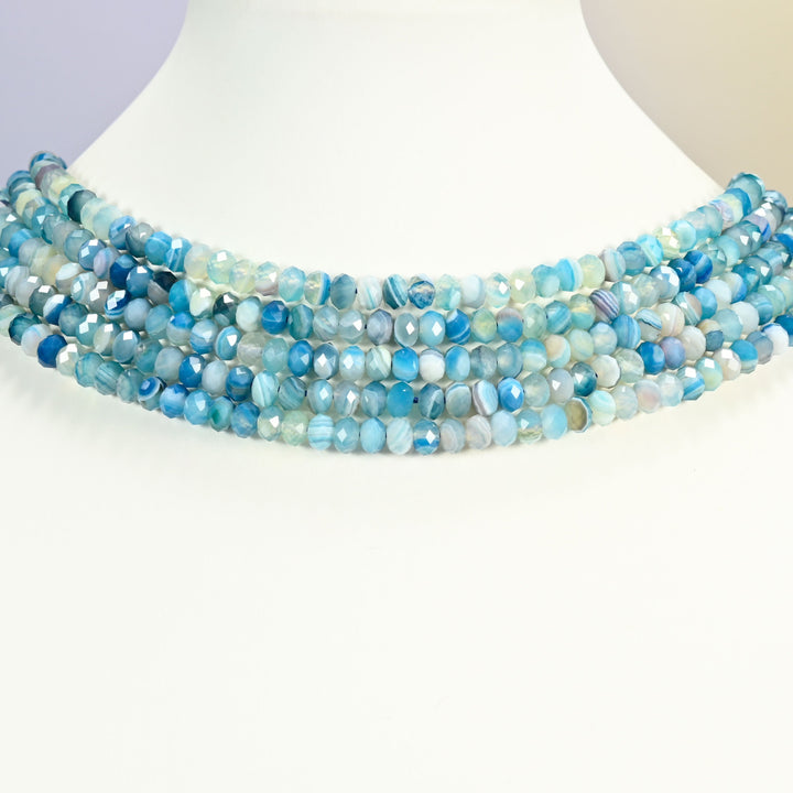 Dyed Blue Strip Agate gemstone rondelle beads 4x6mm shown on a white neck display as a layered necklace