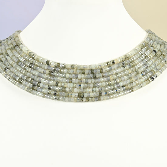 White labradorite faceted heishi disc strands arranged as a layered collar on a white display bust, light gray beads across the neck