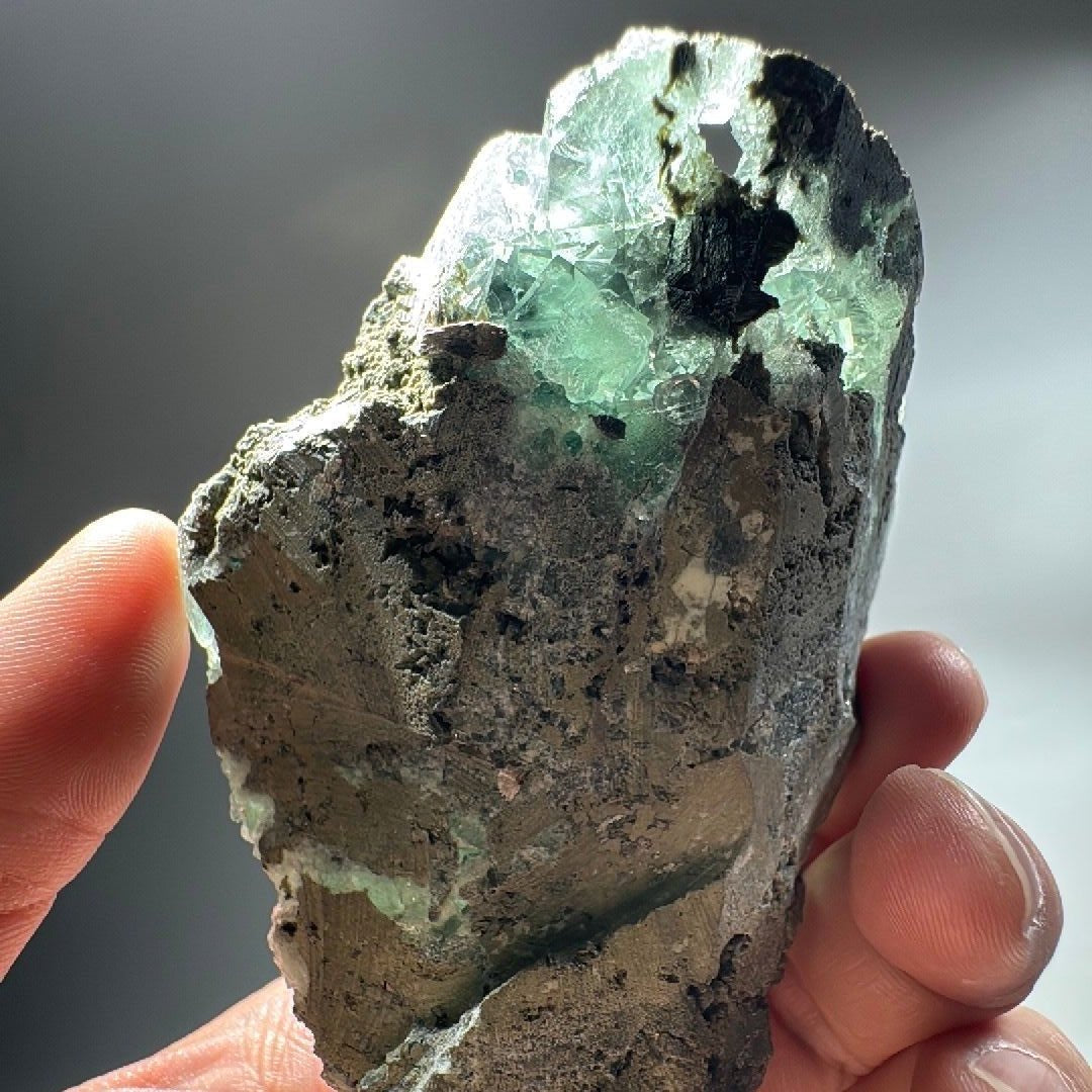 Back of the Fluorite specimen showing the dark rocky matrix it grew on