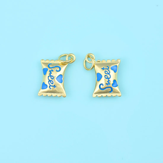 A wrapped sweet in polished 18K gold filled brass, pinched at both ends with a scalloped edge, the word Sweet scripted…