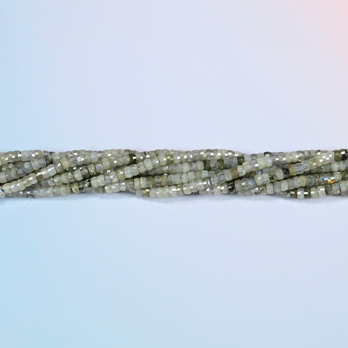 Strands of white labradorite faceted heishi disc beads twisted together in a horizontal row