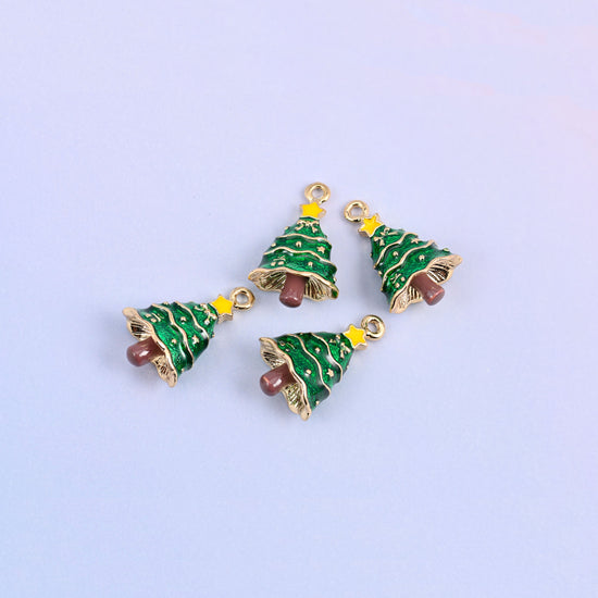 Five christmas tree charms scattered in a group, green enamel with gold garland tiers and raised gold baubles.