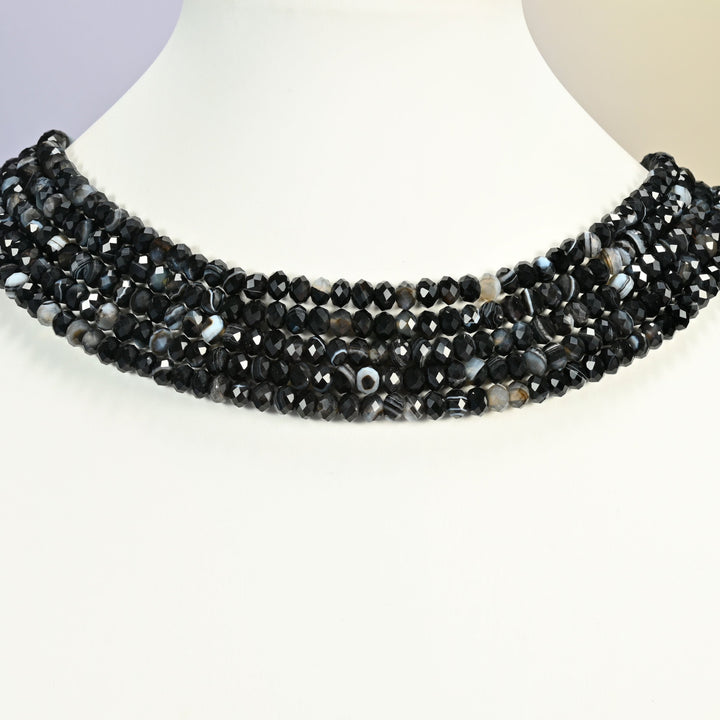 Dyed Black Strip Agate gemstone rondelle beads 4x6mm shown on a white neck display as a layered necklace