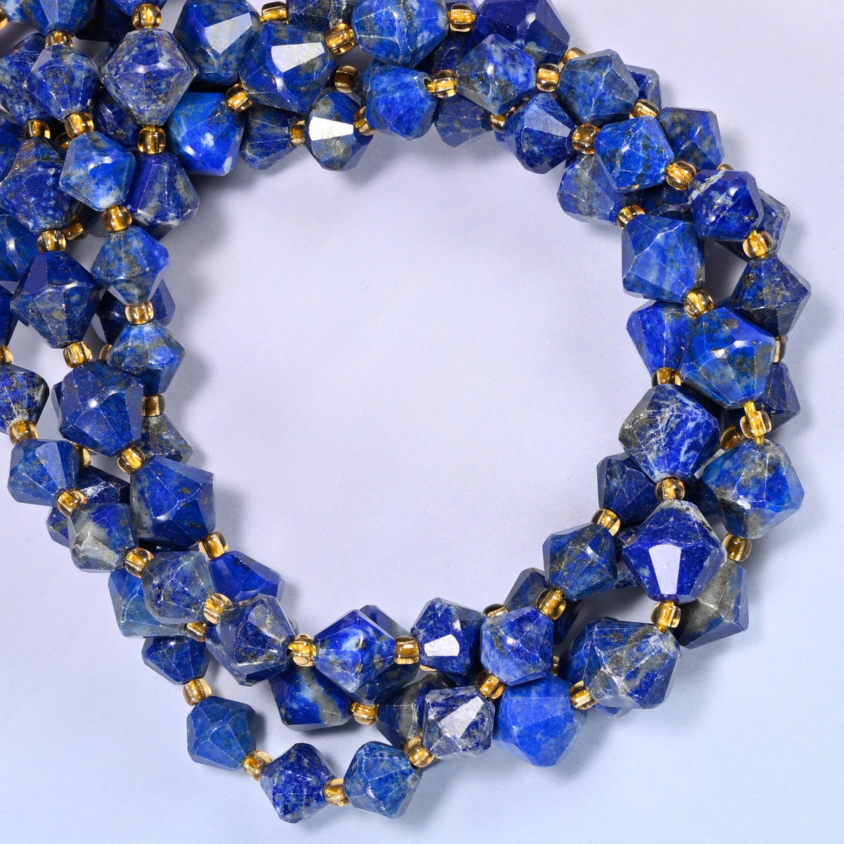 Lapis lazuli bicone beads coiled into a round ring of several strands, rich royal blue carrying around the full coil.