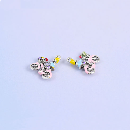 Bicycle charm next to a second turned over to show the plain white gold plated back.