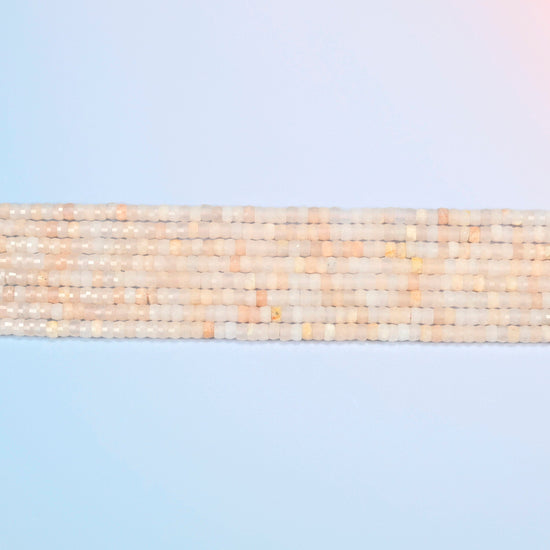 Several strands of pink aventurine faceted heishi disc beads laid in straight rows