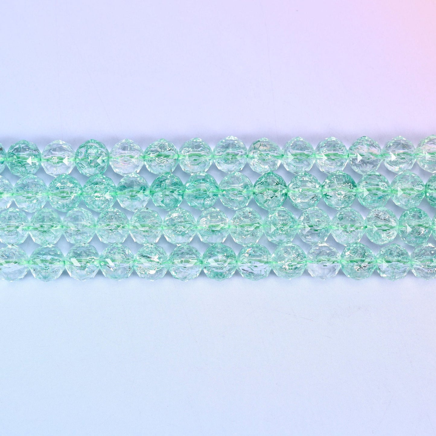 Transparent green faceted round glass beads in pale mint-green