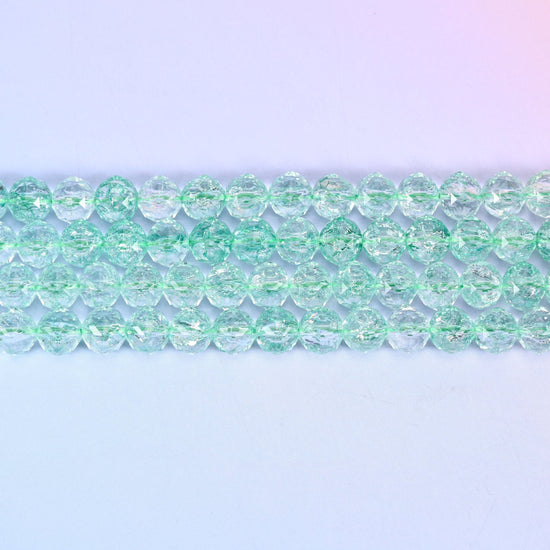 Transparent green faceted round glass beads in pale mint-green