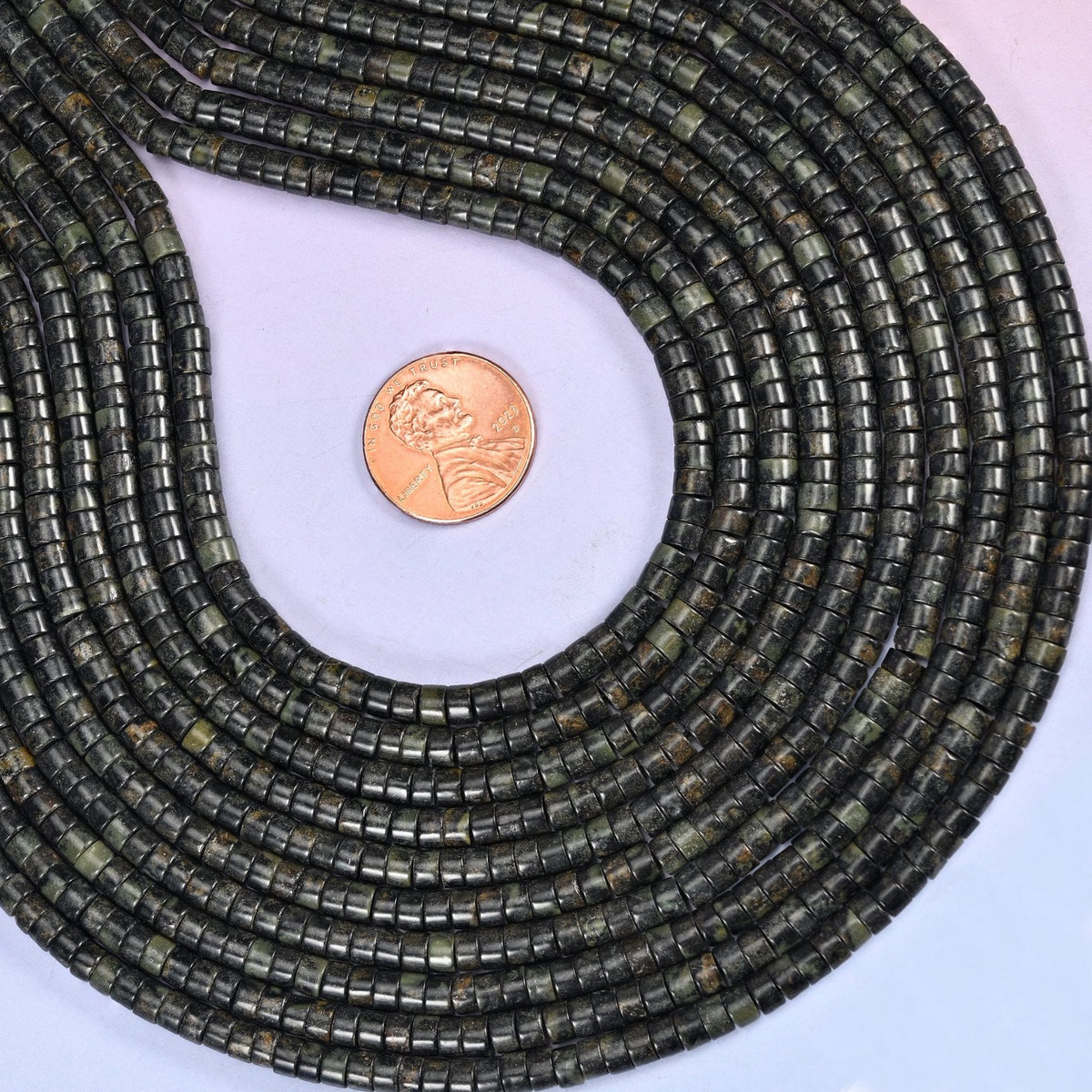 Natural Kambaba Jasper smooth heishi disc beads in deep forest green to black with distinctive circular orbicular patterns, finished with a polished, sophisticated look.