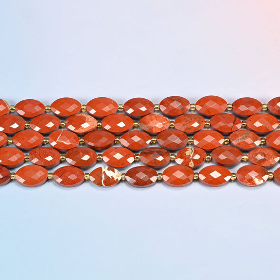 Several strands of flower red jasper faceted flat oval beads laid in straight rows with gold seed bead spacers