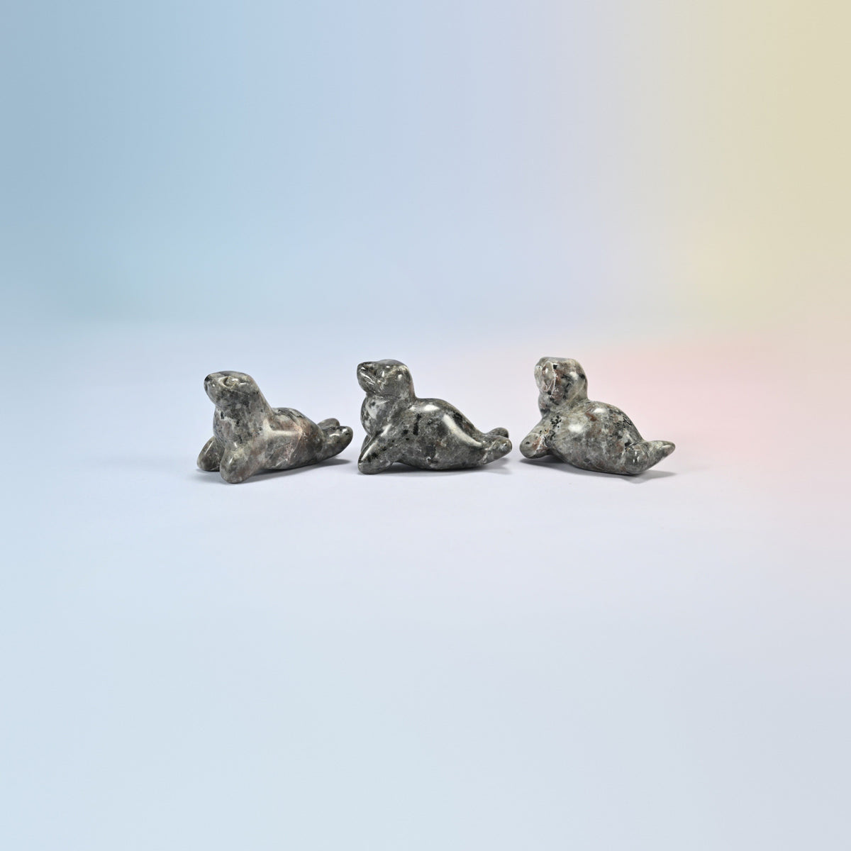 Three yooperlite sea lion crystal carvings, 1.5 inch, light gray natural stone with fine dark speckles