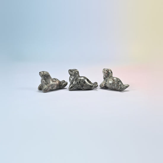 Three yooperlite sea lion crystal carvings, 1.5 inch, light gray natural stone with fine dark speckles