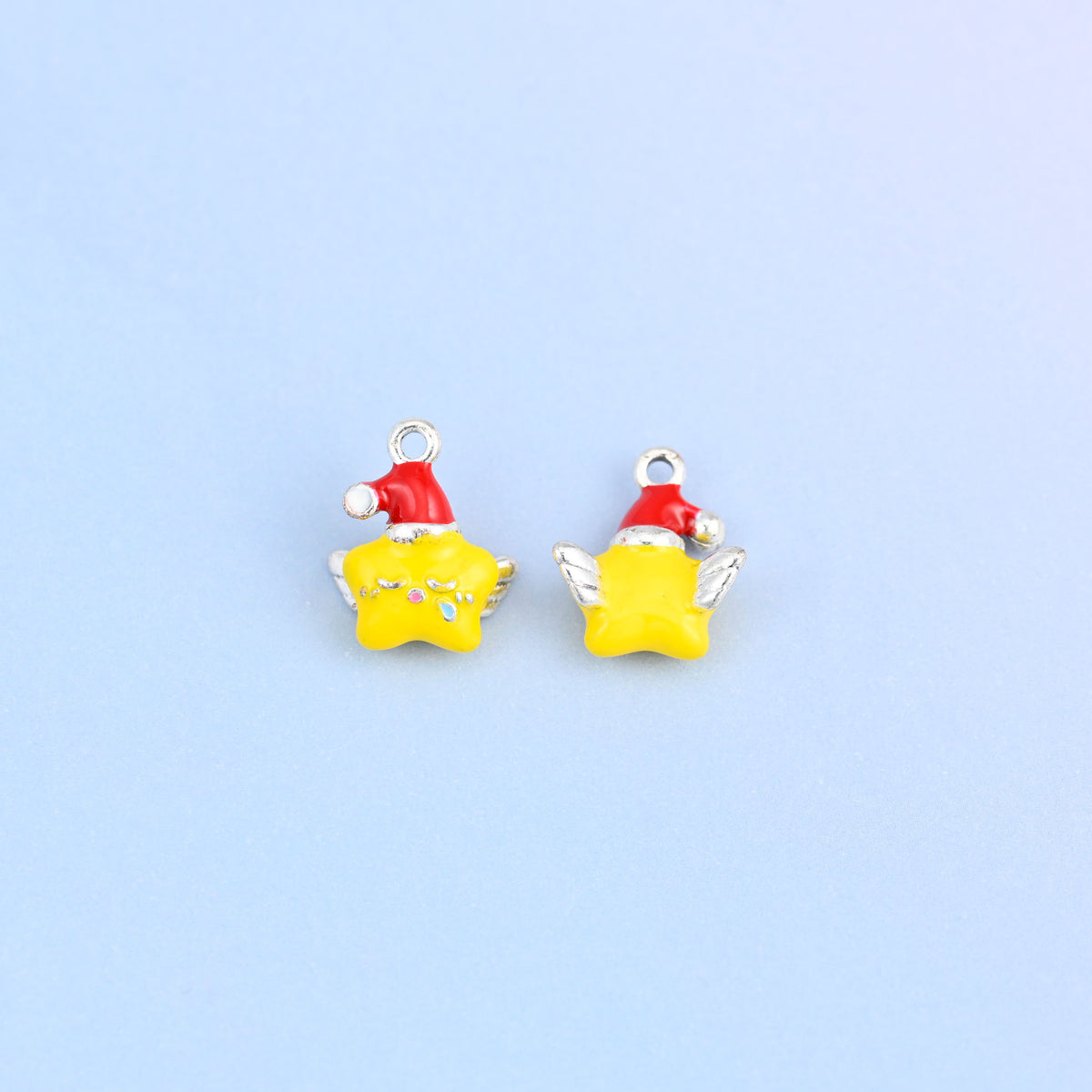 Two star charms in red hats, front and back, with white pom hats and tiny colored dots on the star face.