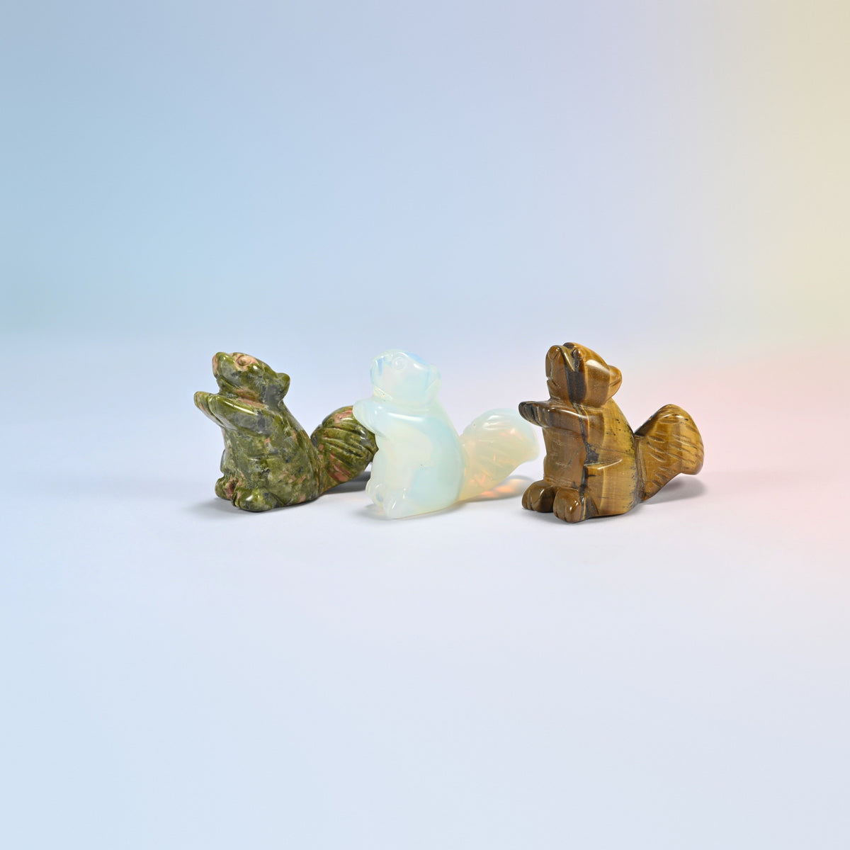 Three 2 inch long tail squirrel crystal carvings in natural unakite, opalite and natural tiger eye