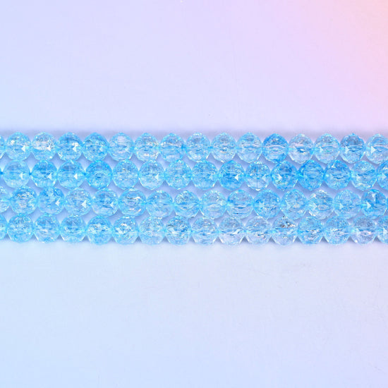 Transparent blue faceted round glass beads in clear sky-blue with fine crackled lines