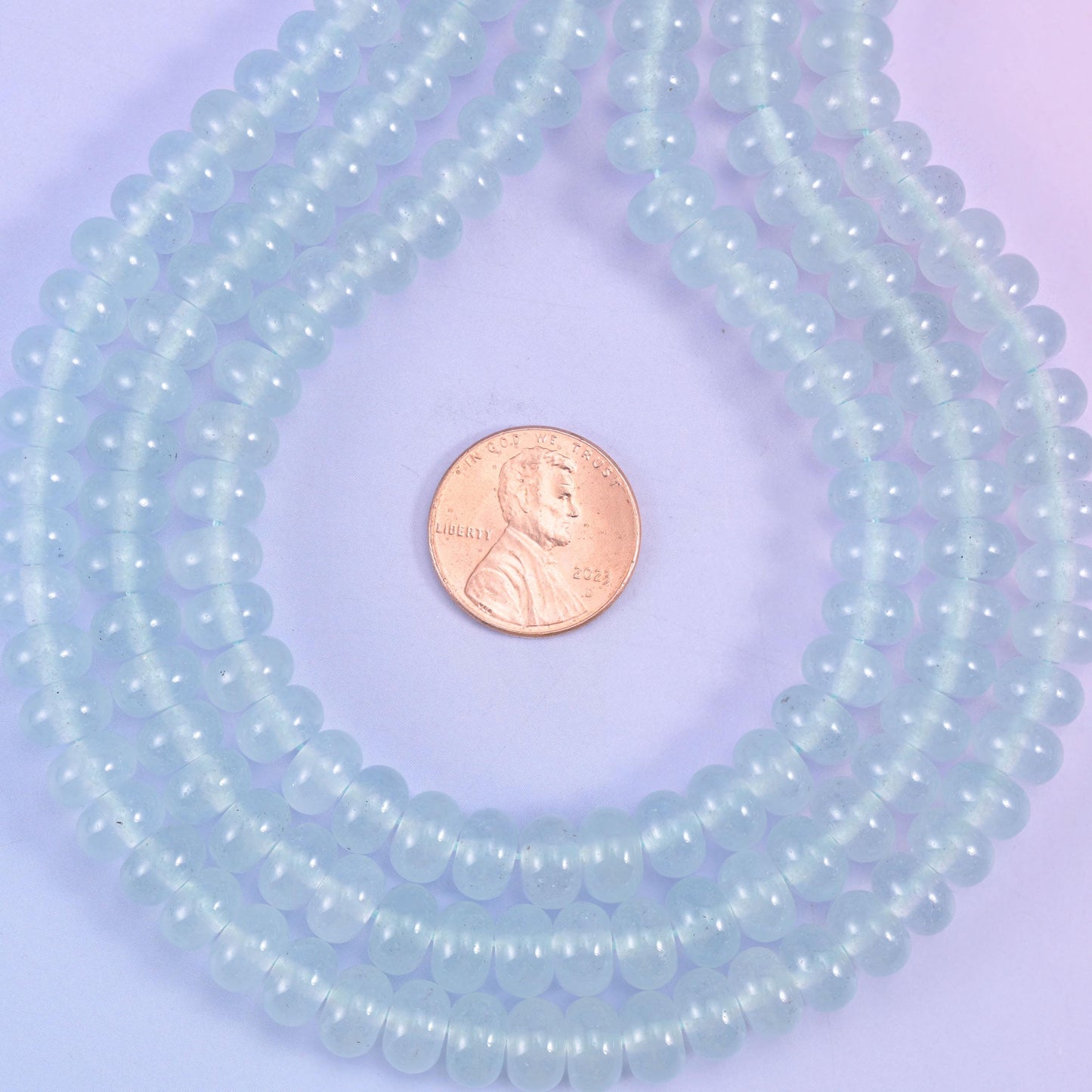 A soft, icy pastel blue under a clean gloss, cut as a slim rondelle — the powdery kind of blue that keeps a design light rather than loud.