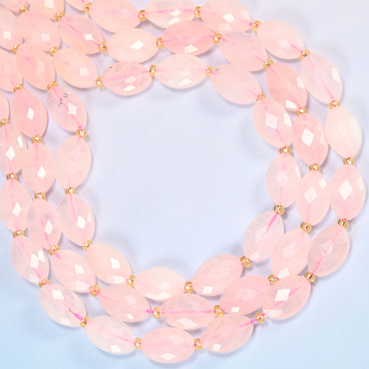 Rose quartz faceted flat oval beads curved into an open loop, translucent blush pink beads