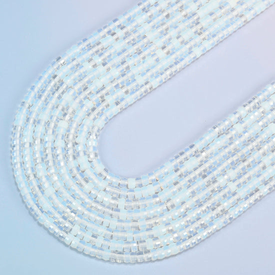 Opalite faceted heishi disc beads in several strands curved into a wide U, translucent milky white glass with a soft blue glow