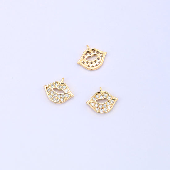 Small gold charms, three gold plated lip charms with one turned to show the plain back