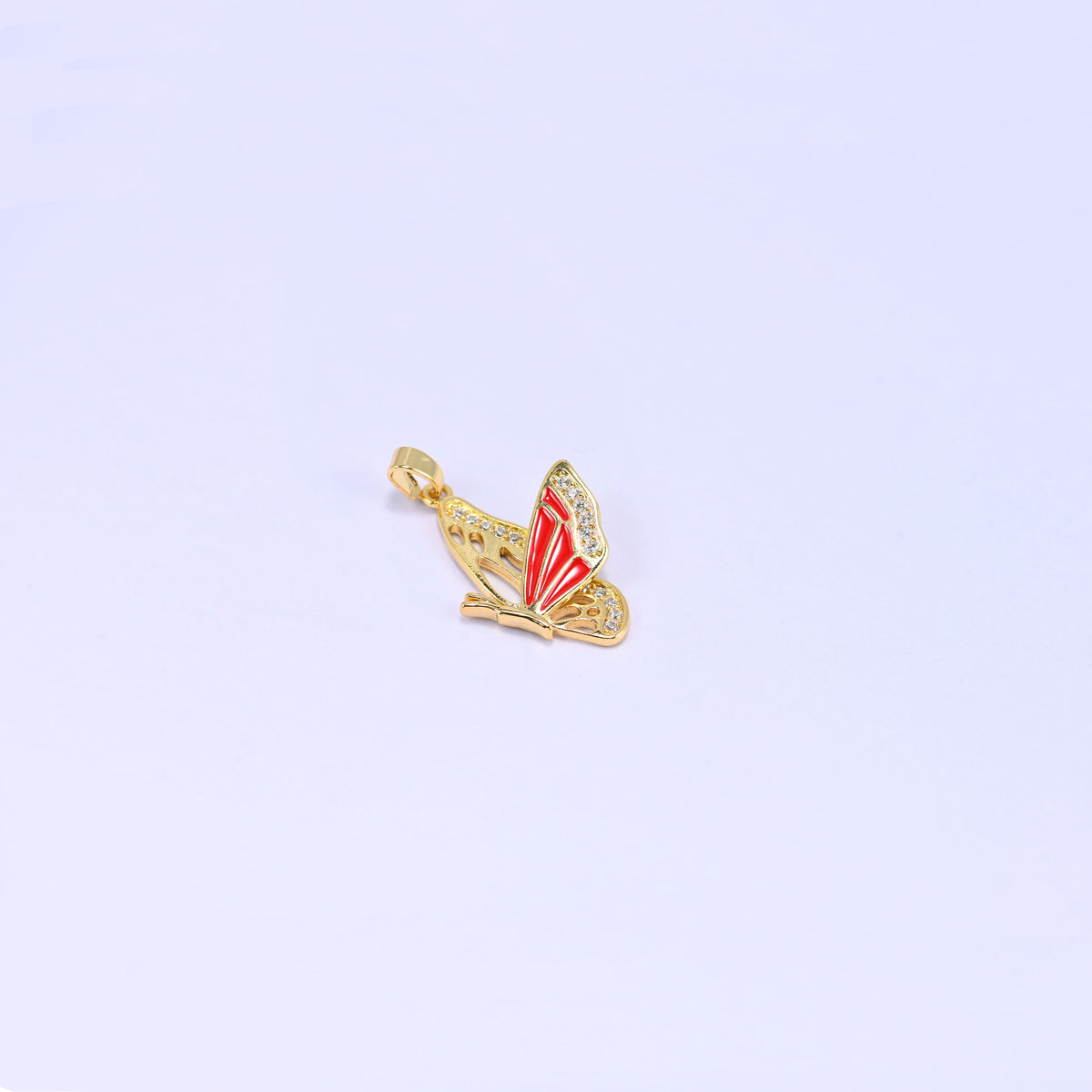 Single flying butterfly charm pendant in red, a small side on butterfly with wings raised, a gold bail and zirconia set along the upper wing.