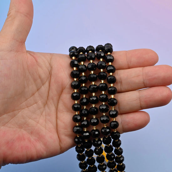 Black onyx faceted rondelle beads in deep jet black with a glassy mirror polish