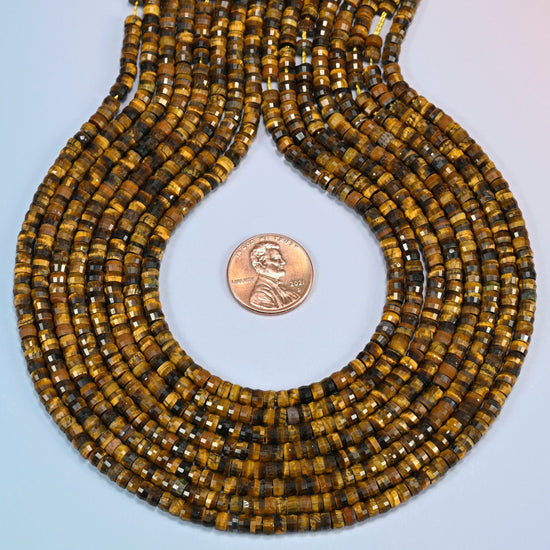 Tiger eye faceted heishi disc strands formed into a teardrop loop around a US penny for scale