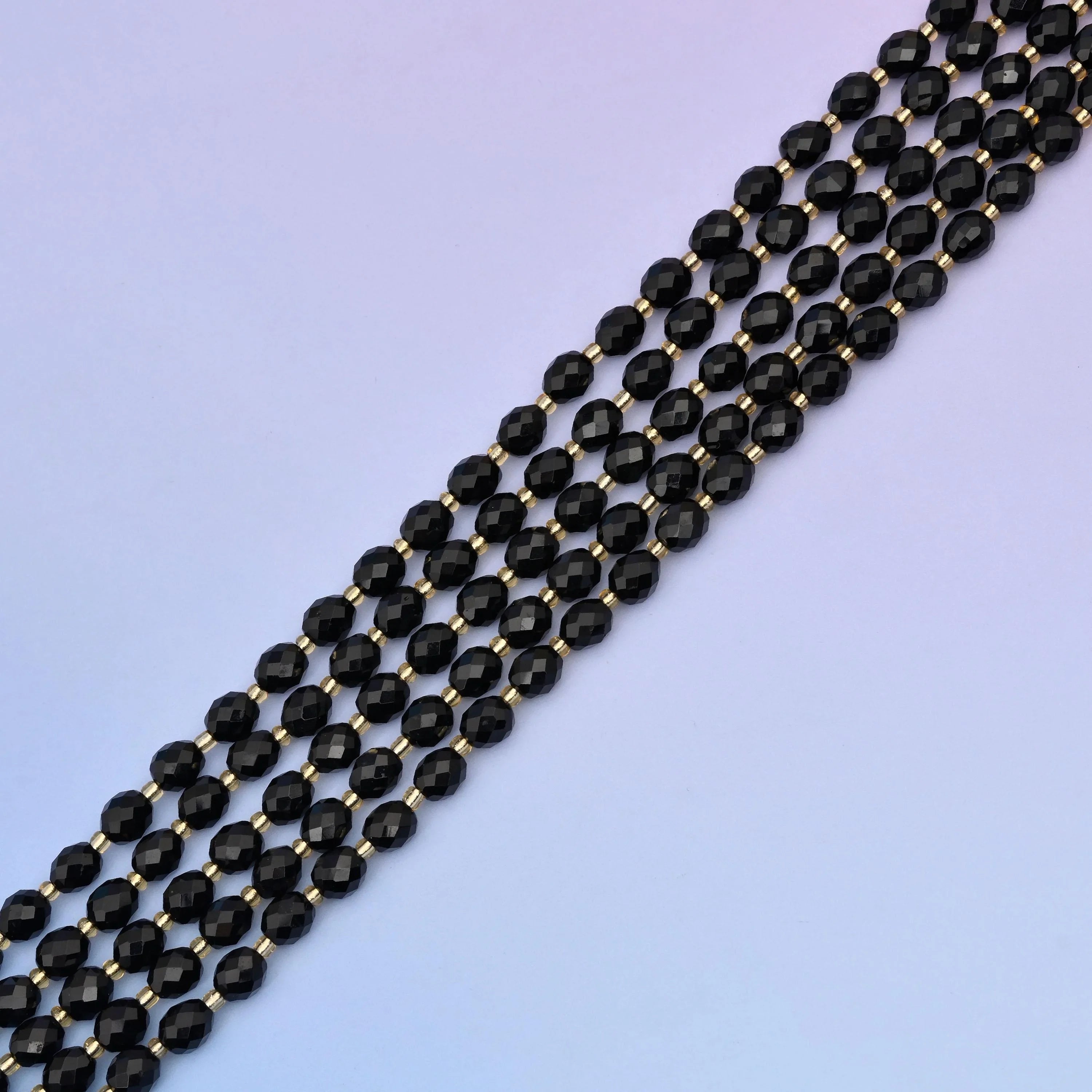 Black Onyx Faceted Rice Barrel Beads, approximately 39 beads per strand.