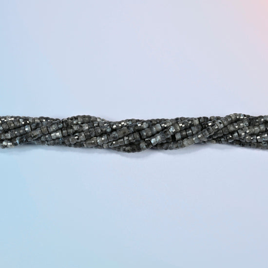 Strands of black labradorite faceted heishi disc beads twisted together in a horizontal row