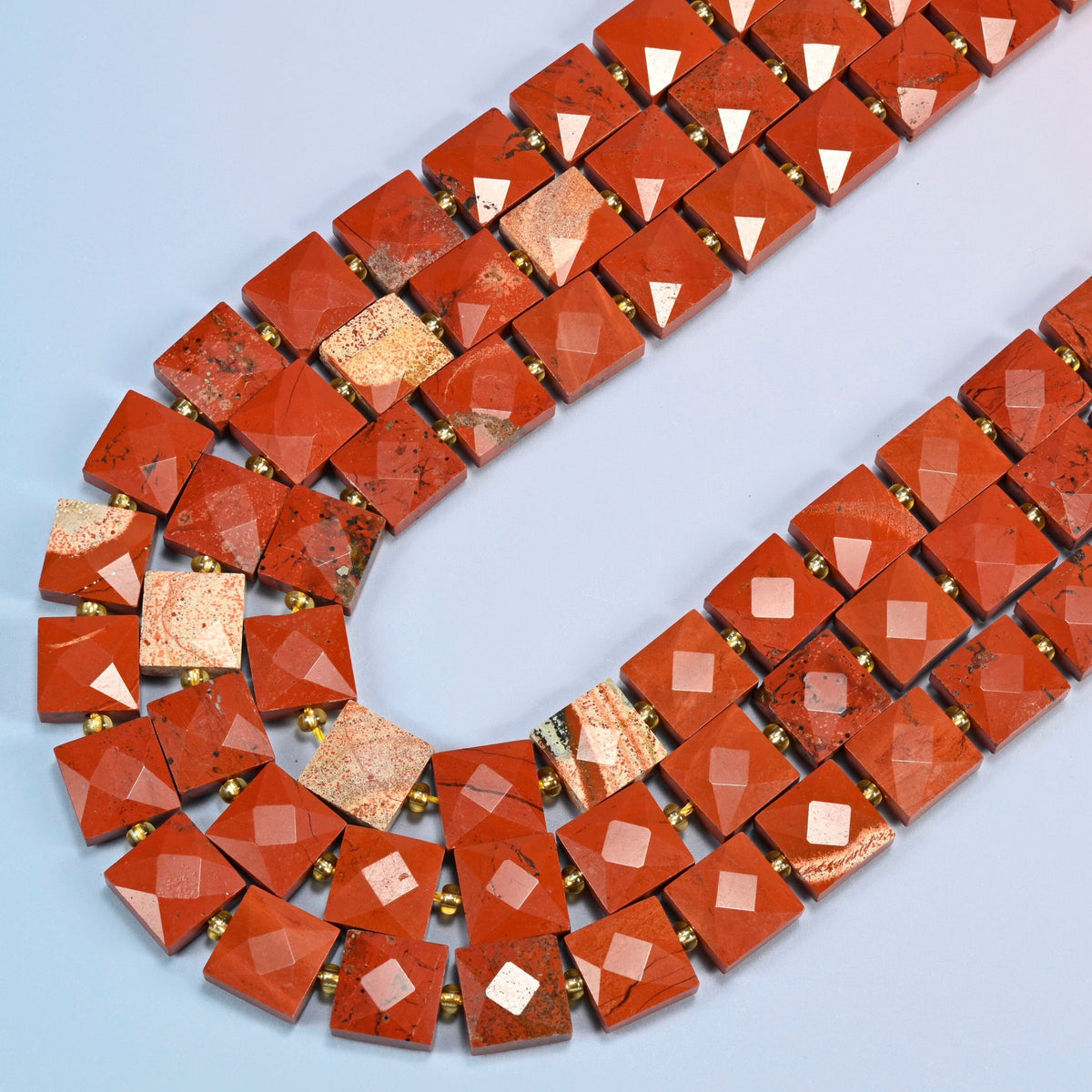 Natural flower red jasper faceted flat square beads in several strands curved into a wide U, brick red stone with cream patterns