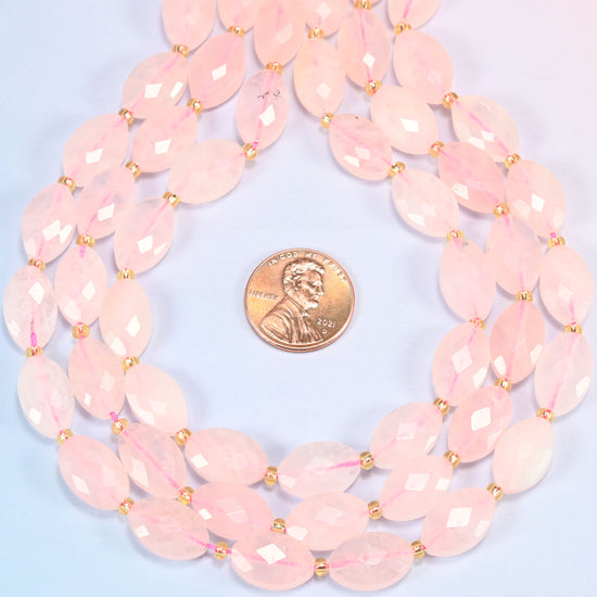 Rose quartz faceted flat oval strands formed into a teardrop loop around a US penny for scale