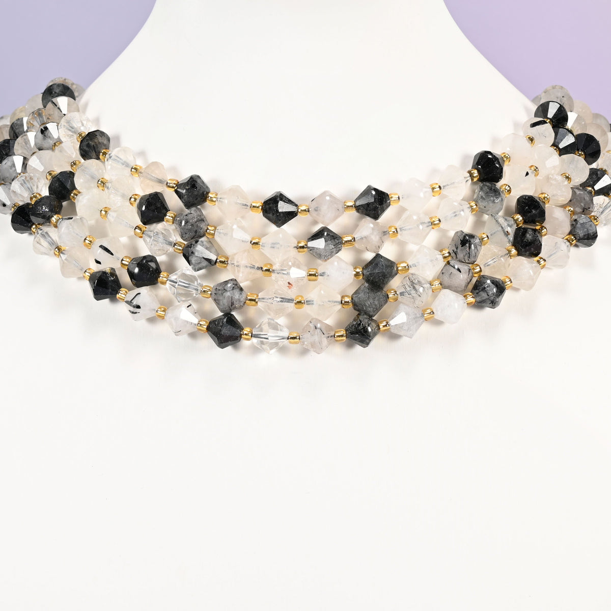 Black rutilated quartz bicone beads curved into a collar, the darkest beads reading almost solid black against the near-clear ones.
