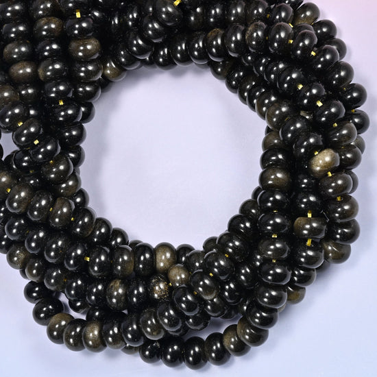 Close-up horizontal row of Gold Obsidian beads showing the black and gold shimmer pattern.