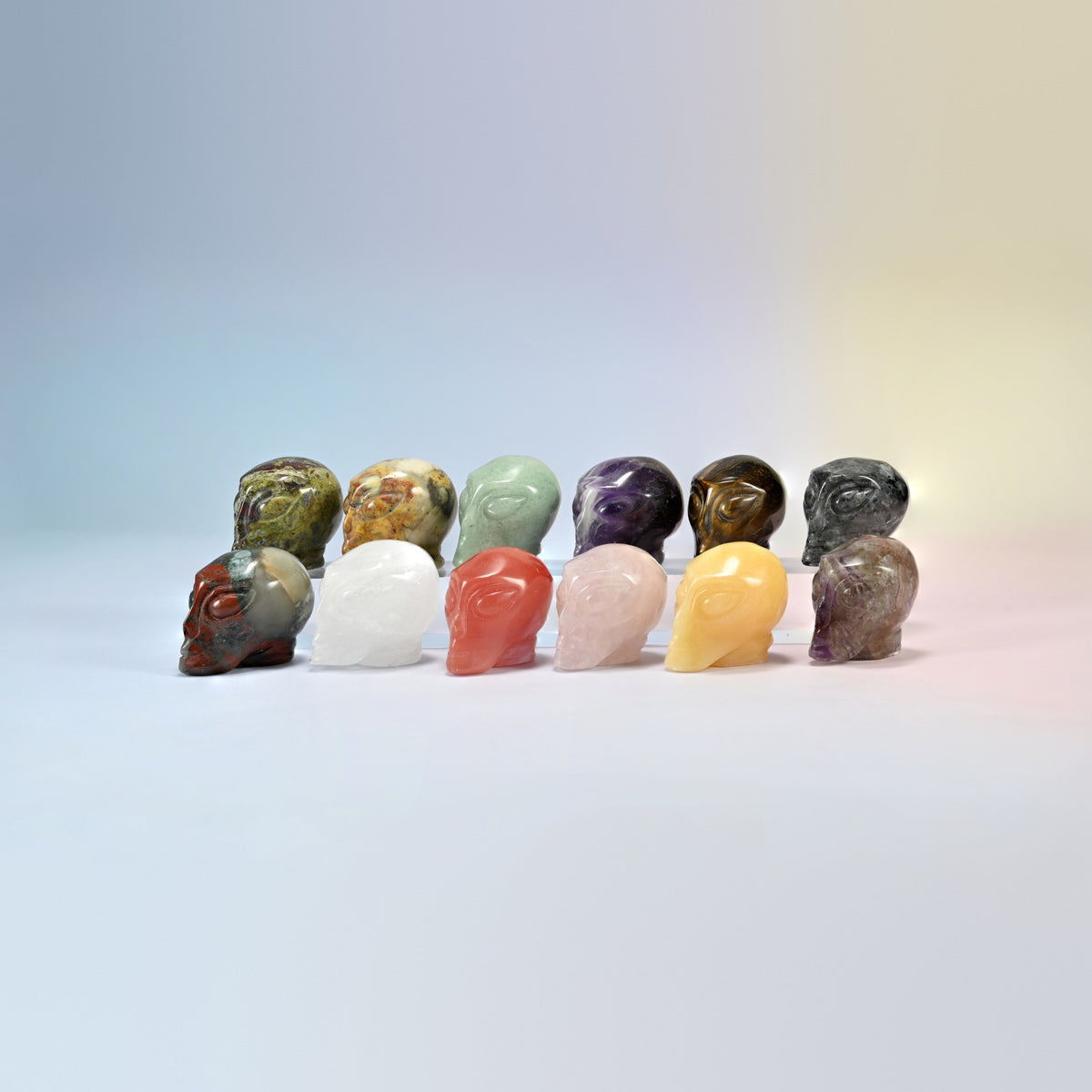 Group of 1.5 and 2 inch alien head crystal carvings in natural stones including moss agate, crazy agate, green aventurine, amethyst, tiger eye, clear quartz and rose quartz