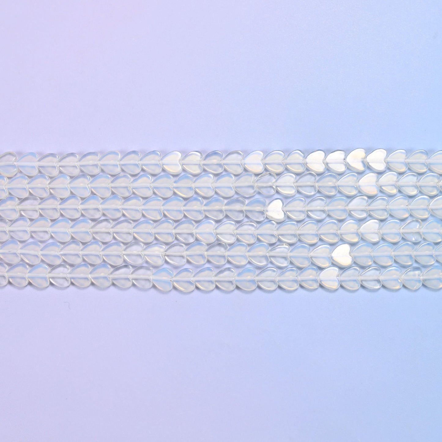 Opalite Flat Heart Beads in milky white with a blue opalescent glow