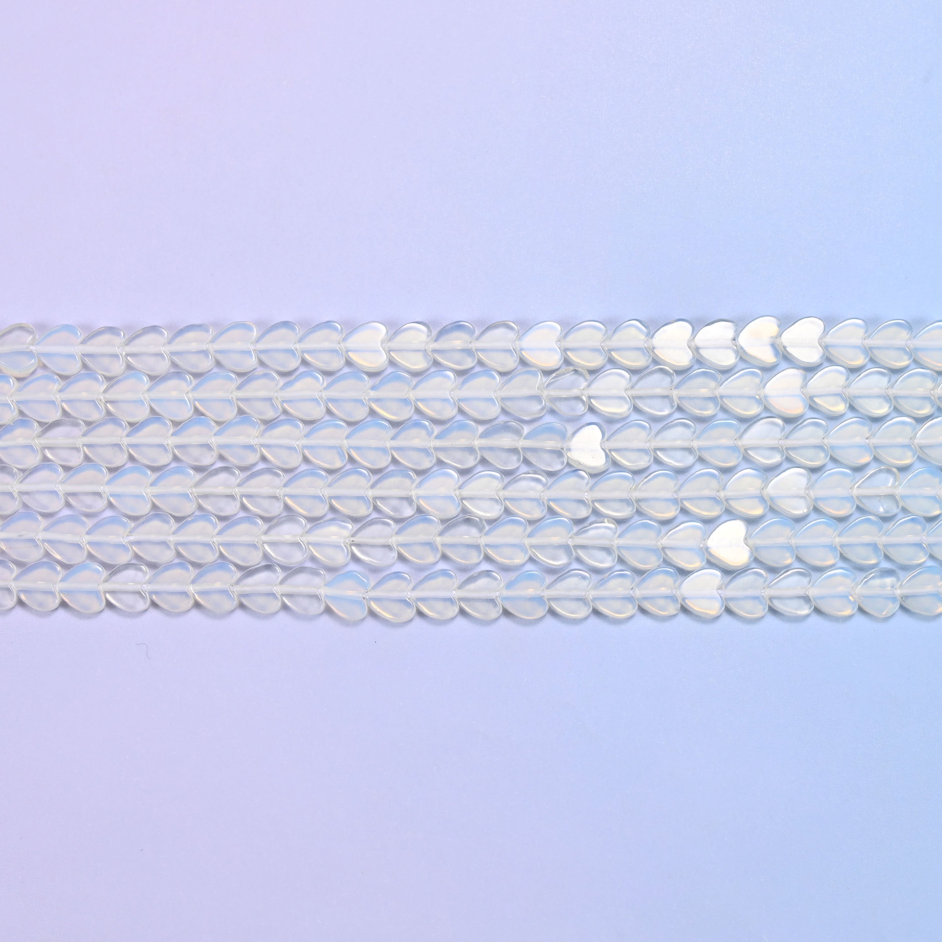 Opalite Flat Heart Beads in milky white with a blue opalescent glow