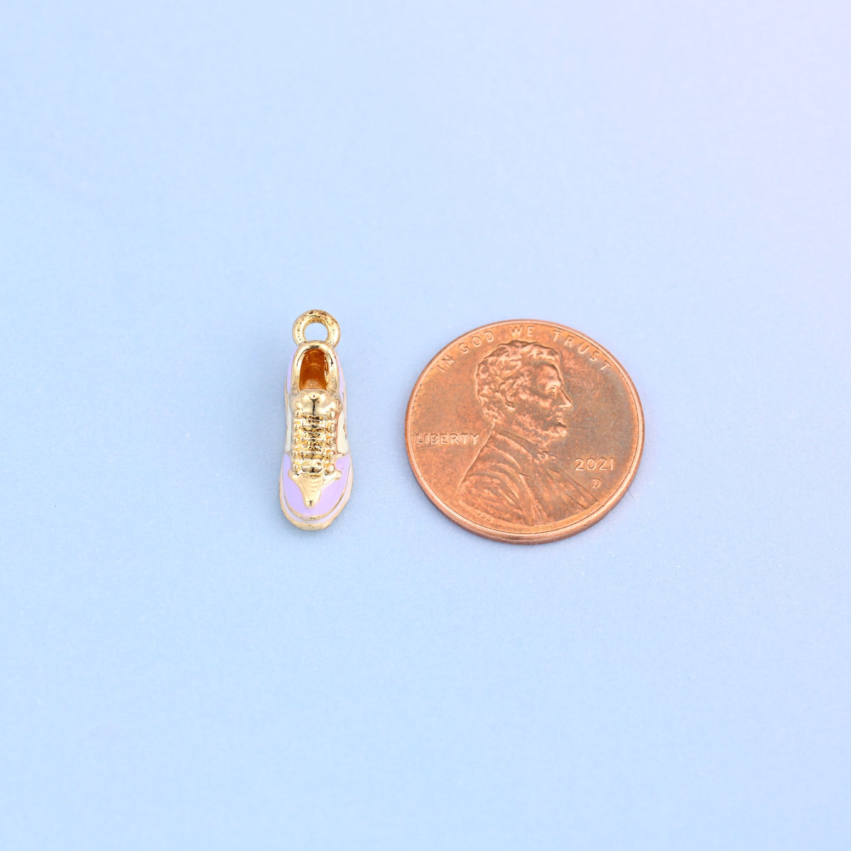 Light purple sneaker charm seen from above, shown at actual size, 17.27 x 7.48mm.