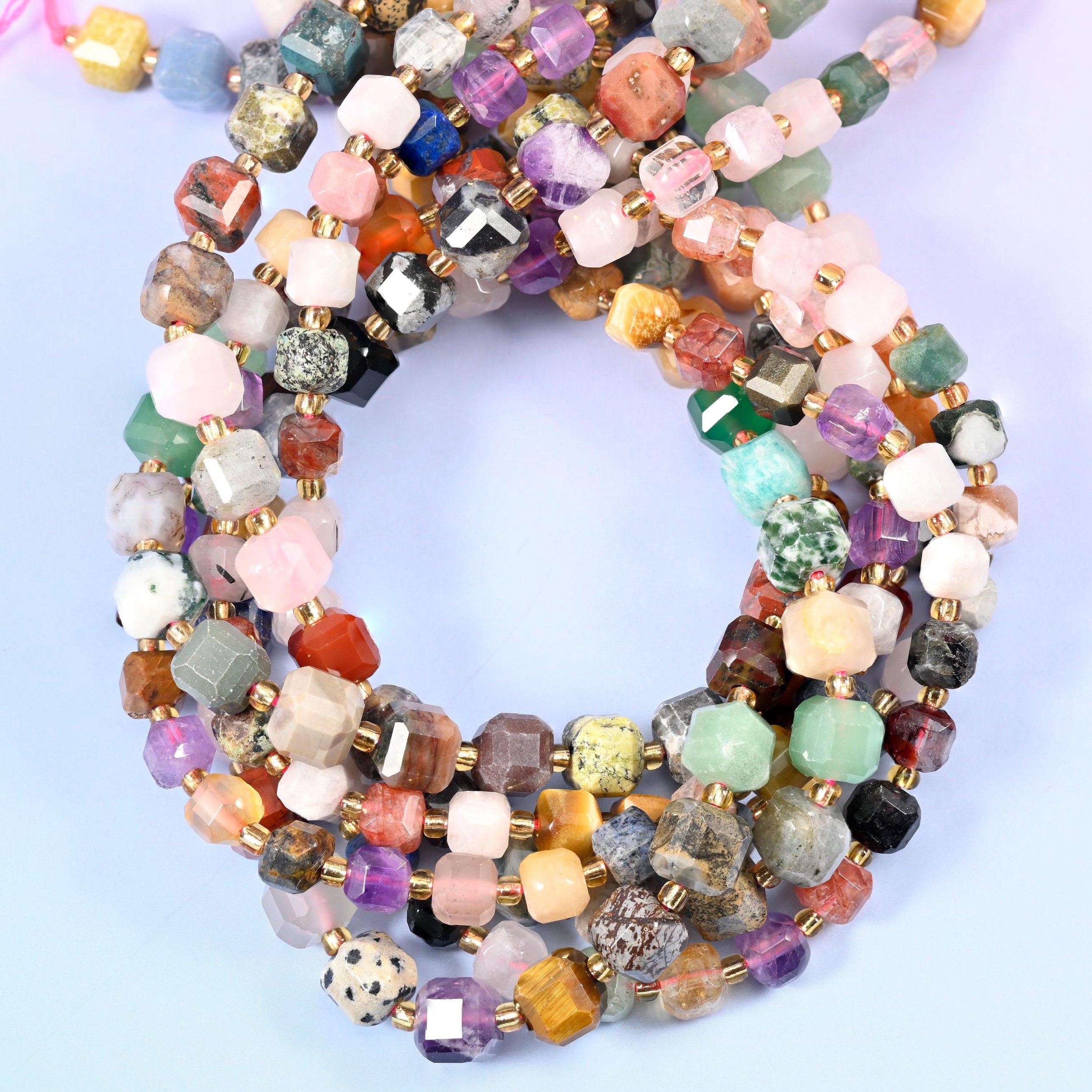 A whole palette on one strand — rose pink, amethyst purple, mint green, golden tiger eye, brick red jasper, spotted cream dalmatian and smoky grey