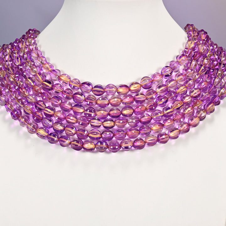 Purple gold pumpkin glass beads shown as layered strands on a white neck display form.