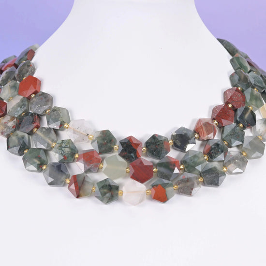Sage green and rust red Bloodstone hexagons displayed on a white neck form