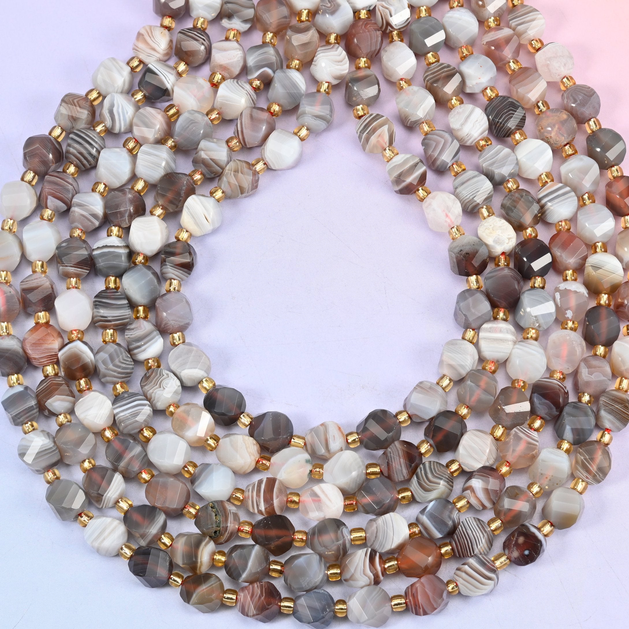 Botswana agate natural stone beads showing concentric eye rings on several beads within the banded pattern