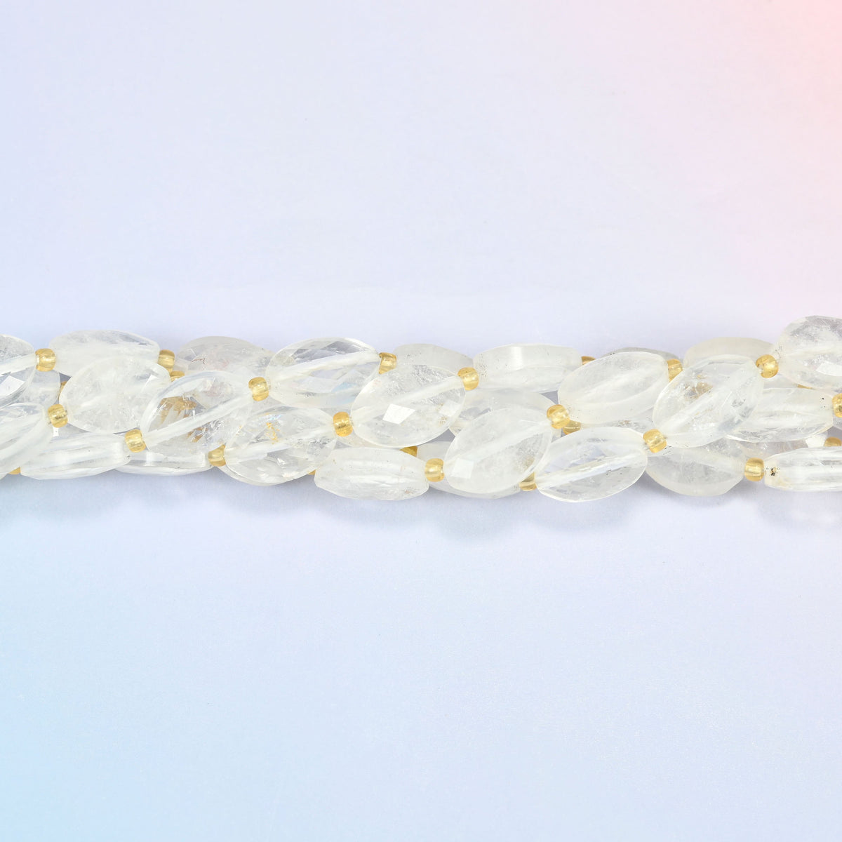 Strands of clear quartz faceted flat oval beads twisted together in a horizontal row