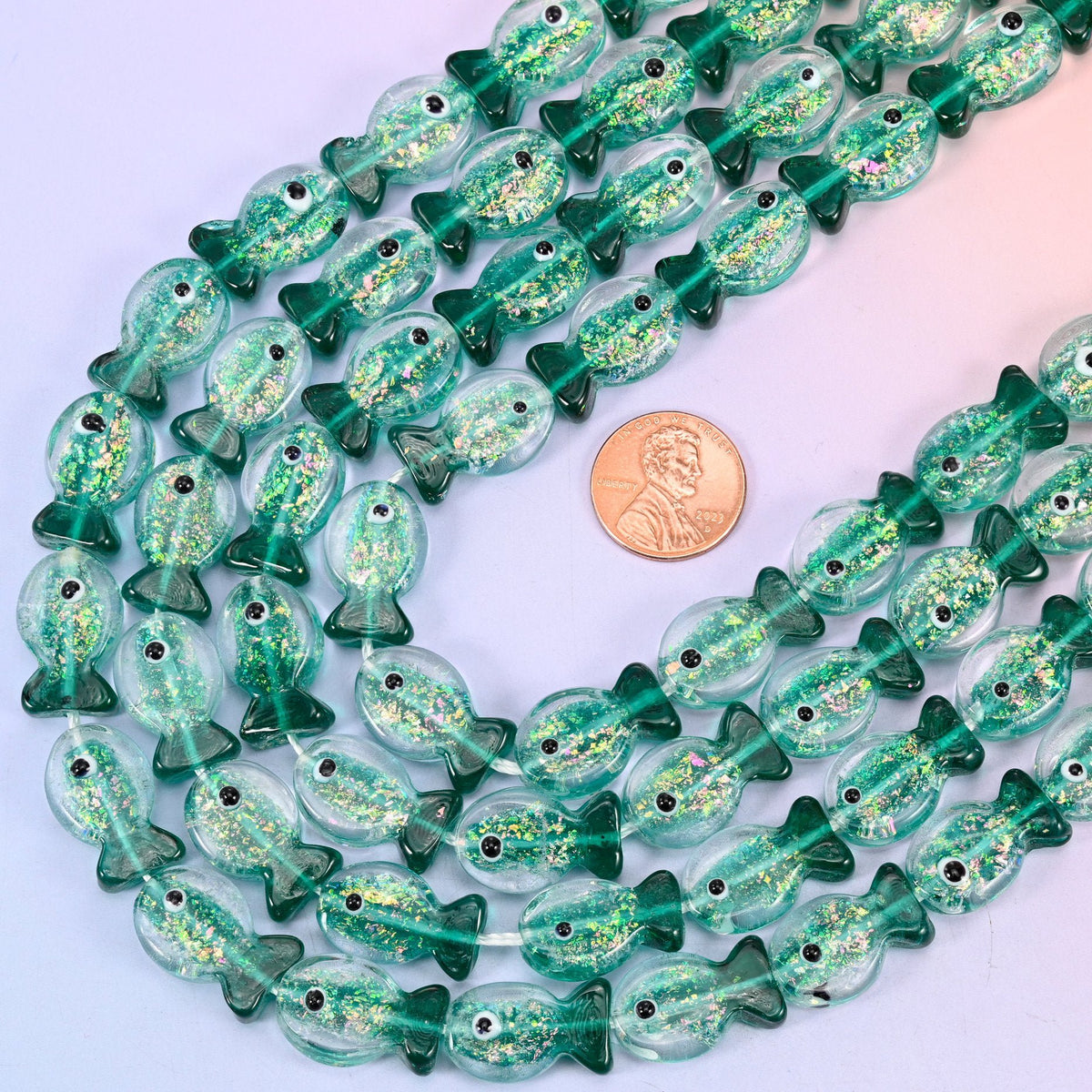 Fish shaped iridescent green glass beads