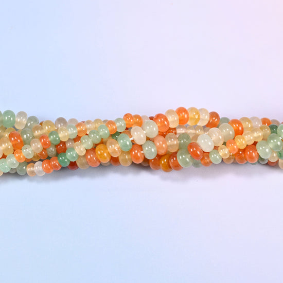 Gold Silk Jade gemstone rondelle beads twisted together, showing how the discs stack into a ribbed line