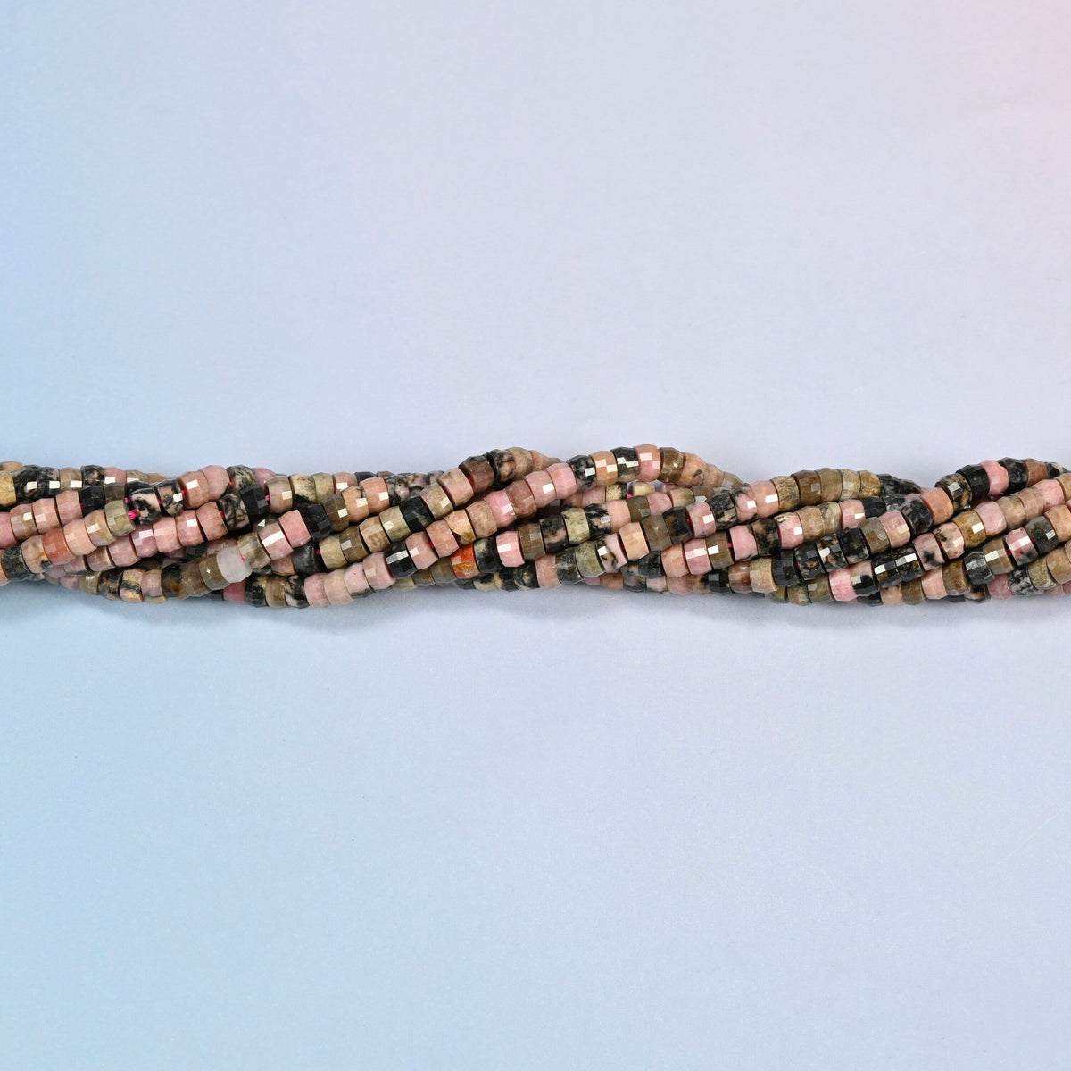 Strands of rhodonite faceted heishi disc beads twisted together in a horizontal row