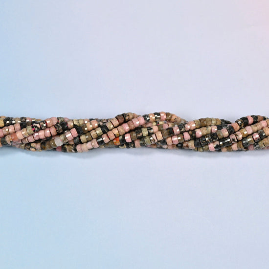 Strands of rhodonite faceted heishi disc beads twisted together in a horizontal row